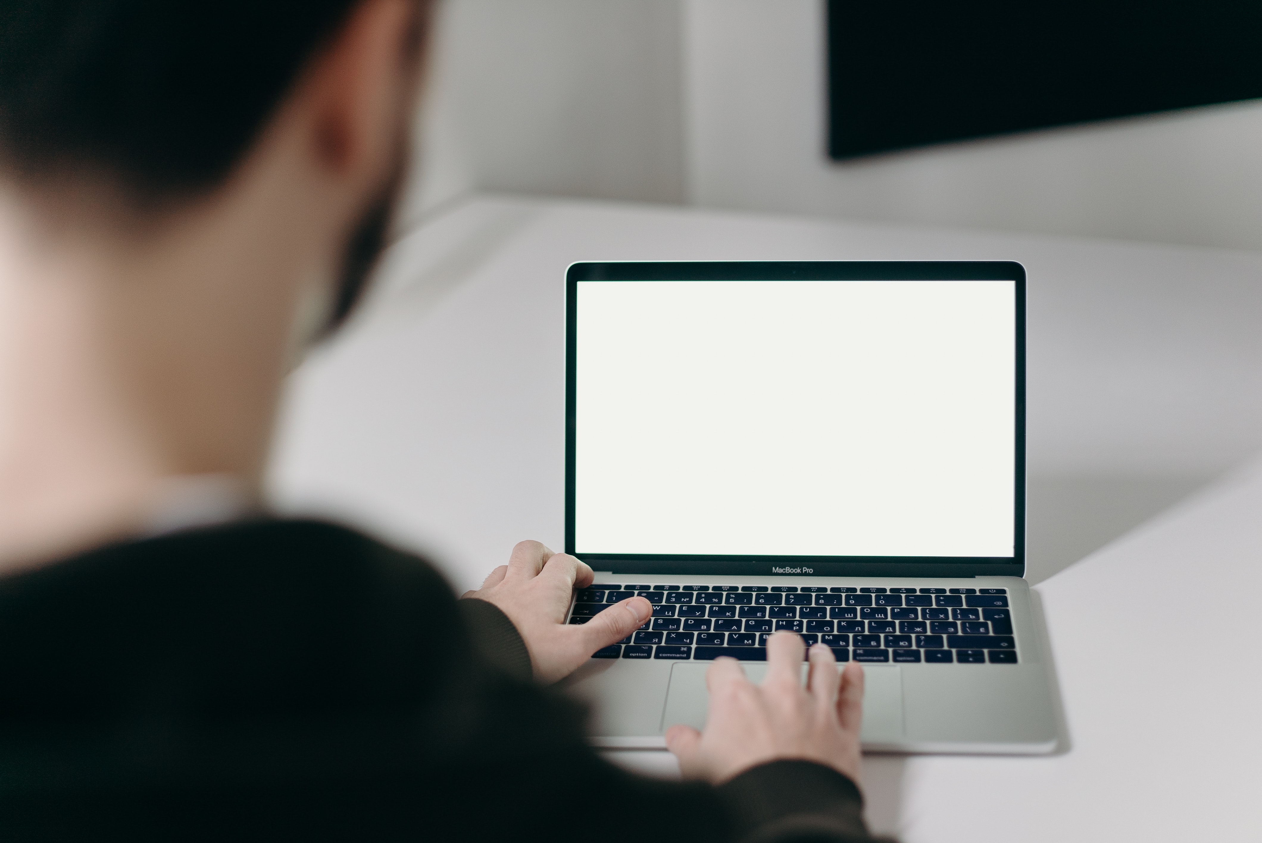 person-using-macbook-pro-on-white-table-4064854